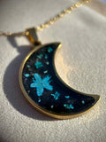 Collier doré avec pendentif en forme de croissant et fleurs séchées