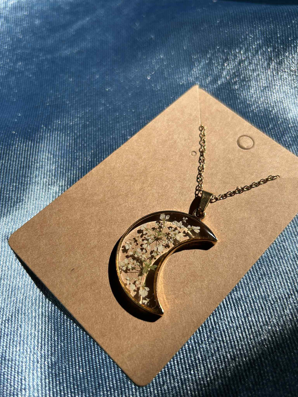 Collier doré avec pendentif en forme de croissant et fleurs séchées