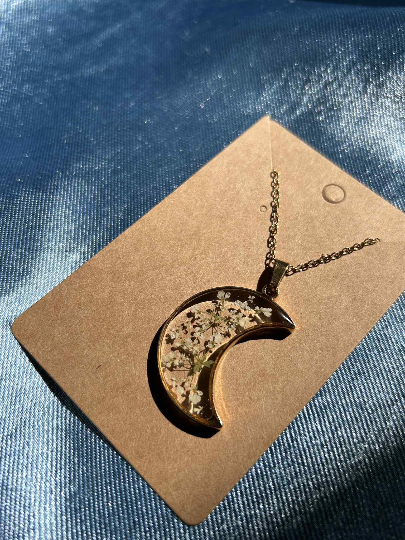 Collier doré avec pendentif en forme de croissant et fleurs séchées