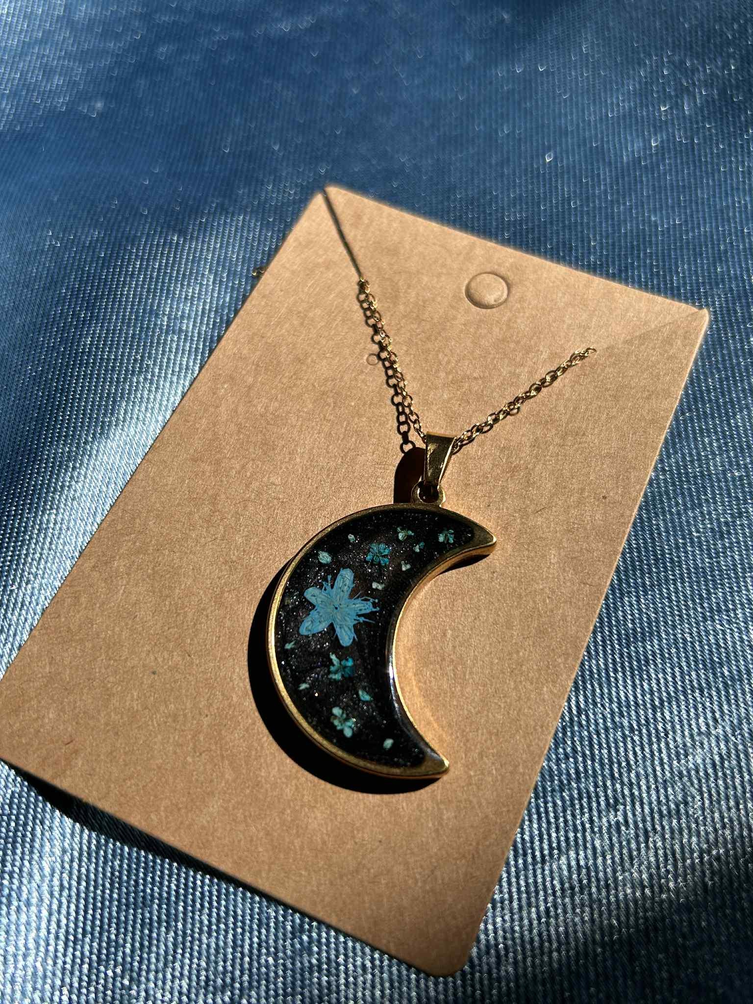 Collier doré avec pendentif en forme de croissant et fleurs séchées