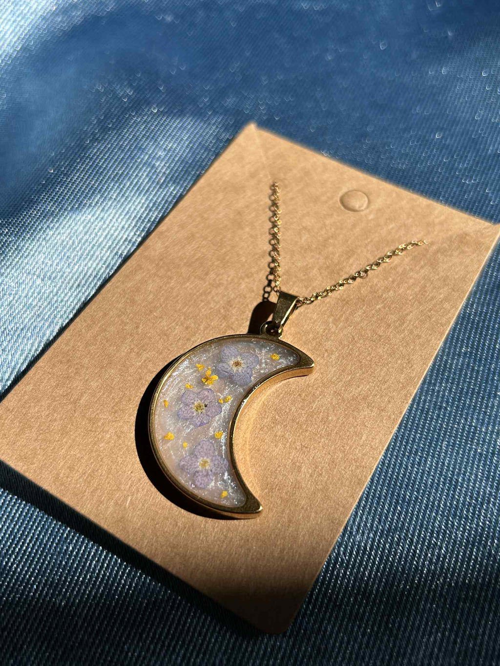 Collier doré avec pendentif en forme de croissant et fleurs séchées
